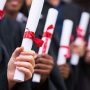 group of multiracial graduates holding diploma